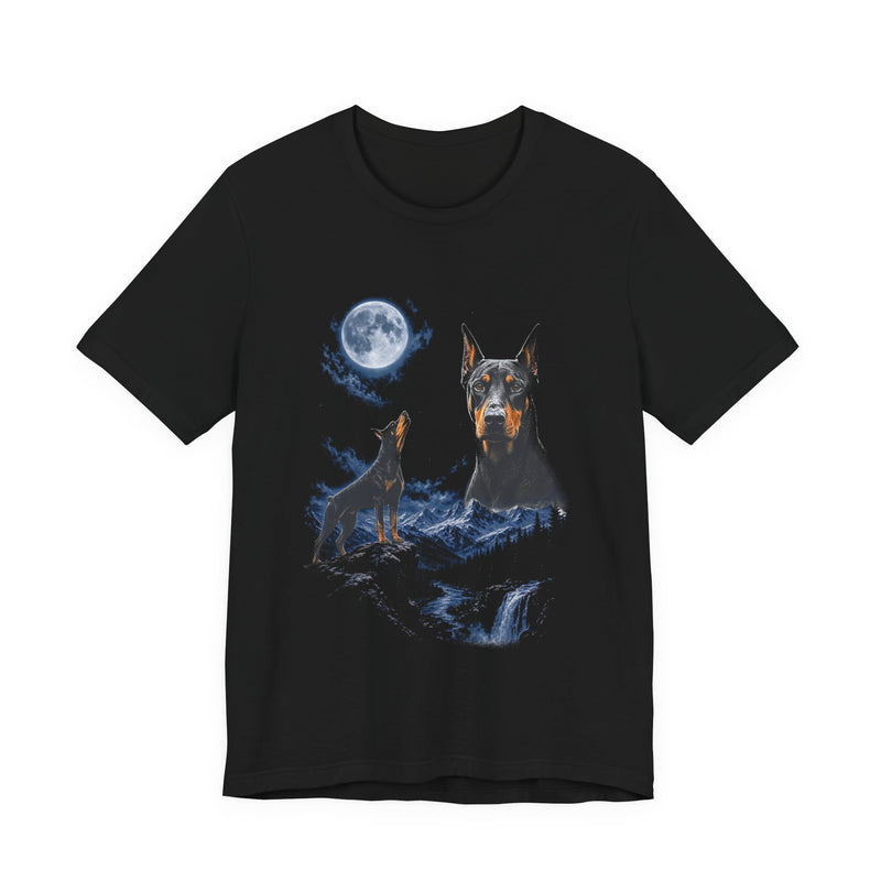 Black t-shirt with a photoreal Doberman under a full moon and a second Doberman howling on a cliff over mountains and a waterfall, front view