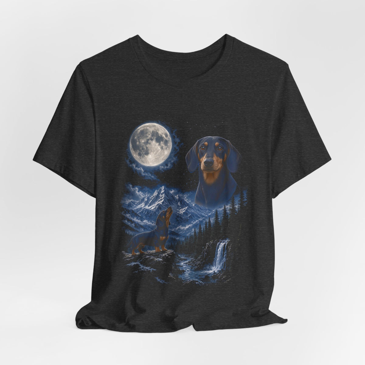 Dark Grey Heather t-shirt with a photoreal miniature dachshund under a full moon and a second miniature dachshund howling on a cliff over mountains and a waterfall, flat lay