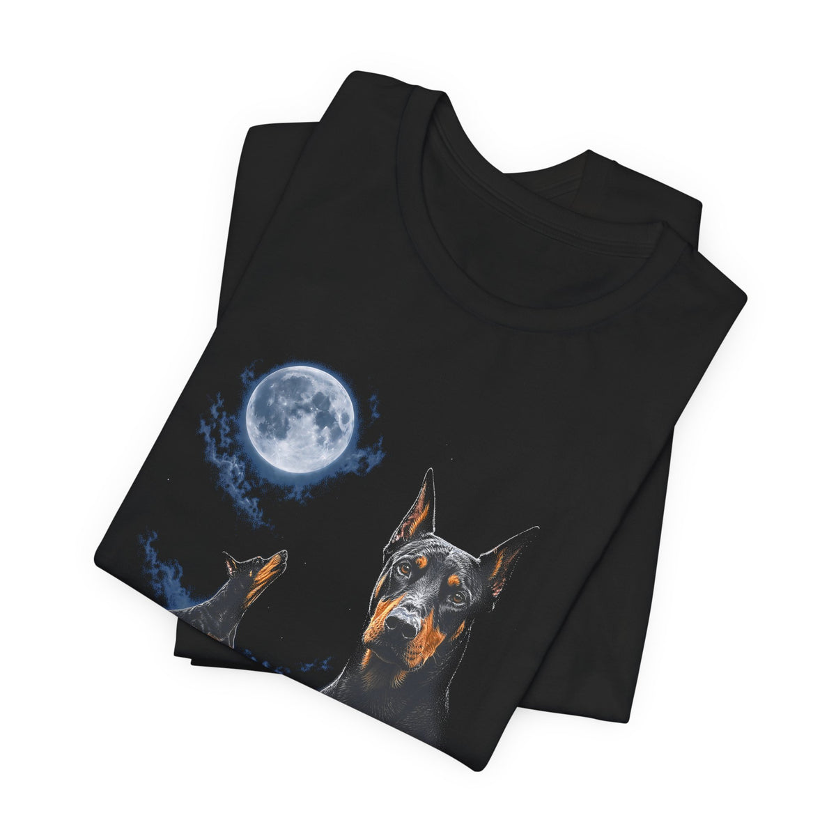 Black t-shirt with a photoreal Doberman under a full moon and a second Doberman howling on a cliff over mountains and a waterfall, folded